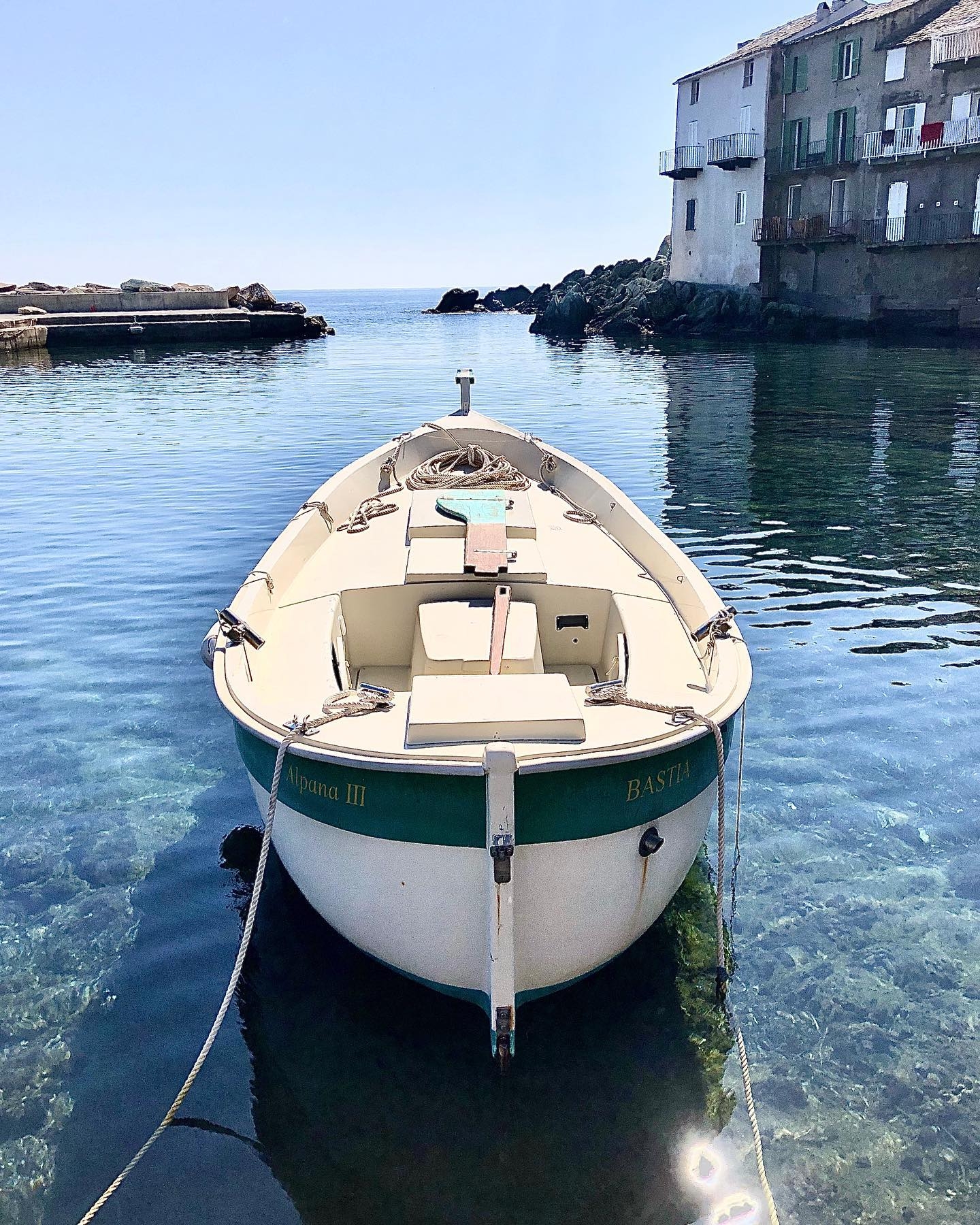 Serene Coastal Solitude: A White Boat at Erbalunga