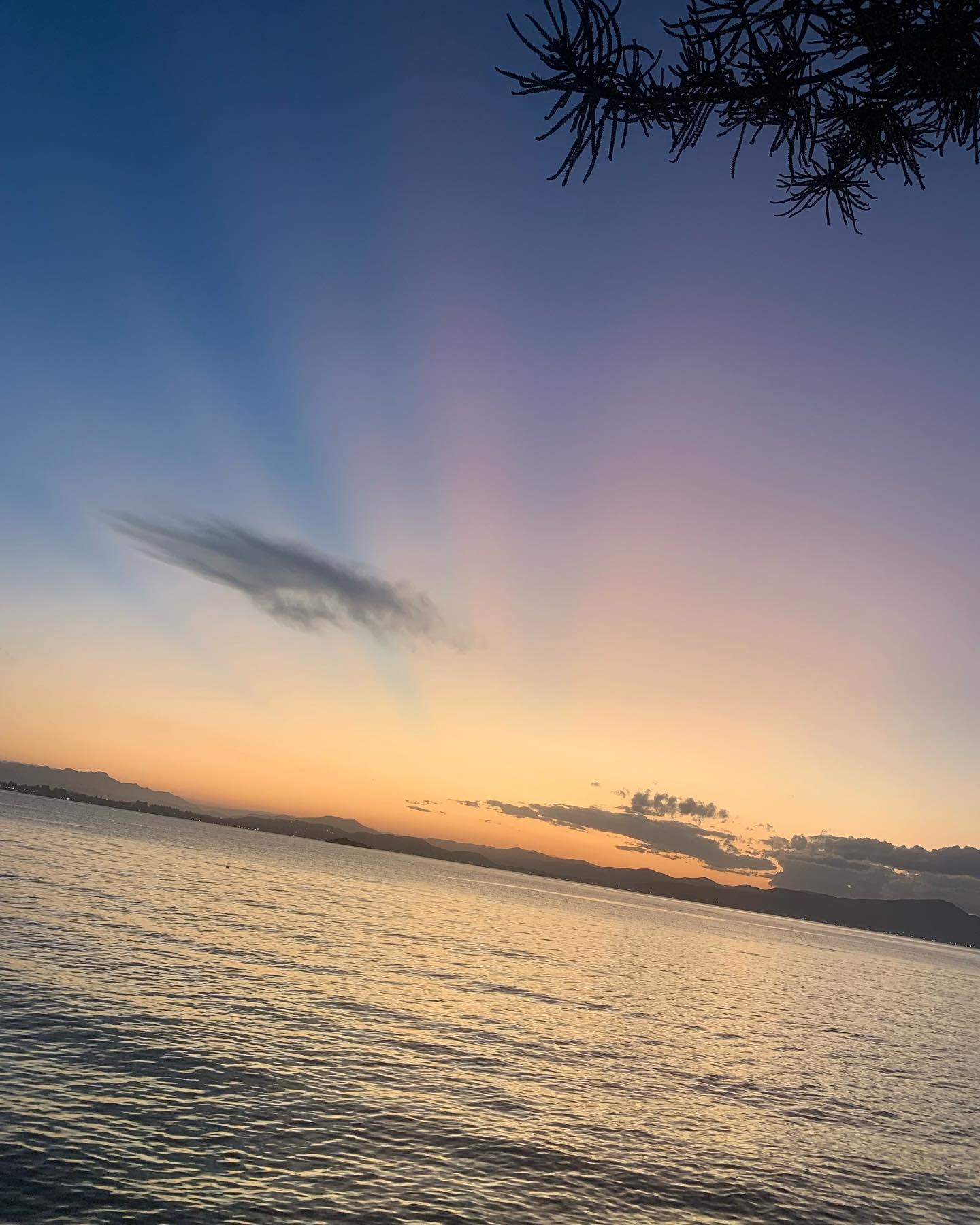 Horizon's Embrace: Serene Sunset over Mountain Lake